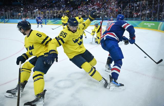 (260219) -- MILAN, Feb. 19, 2026 (Xinhua) -- Erik Karlsson (front C) of Sweden falls during the ice hockey men's play-offs quarterfinal between Sweden and the United States at the Milan-Cortina 2026 Olympic Winter Games in Milan, Italy, Feb. 18, 2026. (Xinhua/Zhang Haofu)