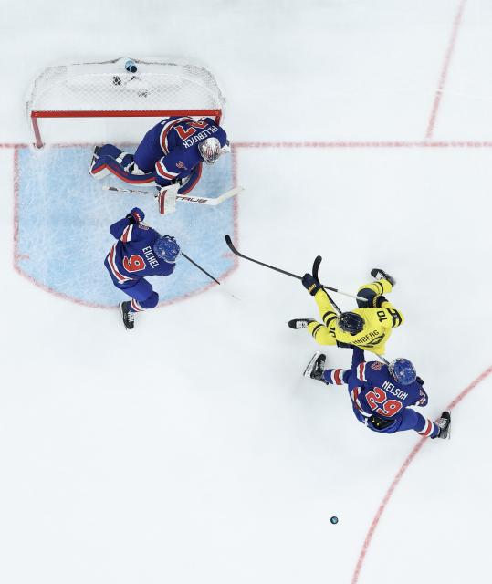 (260219) -- MILAN, Feb. 19, 2026 (Xinhua) -- Players of both teams compete during the ice hockey men's play-offs quarterfinal between Sweden and the United States at the Milan-Cortina 2026 Olympic Winter Games in Milan, Italy, Feb. 18, 2026. (Xinhua/Zhang Haofu)