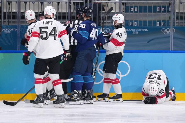 (260219) -- MILAN, Feb. 19, 2026 (Xinhua) -- Players of both teams fight as Switzerland's Nico Hischier (1st R) gets injured during the ice hockey men's play-offs quarterfinal between Finland and Switzerland at the Milan-Cortina 2026 Olympic Winter Games in Milan, Italy, Feb. 18, 2026. (Xinhua/Tao Xiyi)