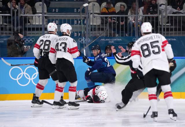 (260219) -- MILAN, Feb. 19, 2026 (Xinhua) -- Switzerland's Nico Hischier (bottom) falls down during the ice hockey men's play-offs quarterfinal between Finland and Switzerland at the Milan-Cortina 2026 Olympic Winter Games in Milan, Italy, Feb. 18, 2026. (Xinhua/Tao Xiyi)