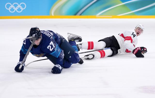 (260219) -- MILAN, Feb. 19, 2026 (Xinhua) -- Eetu Luostarinen (L) of Finland fights for the puck against Dean Kukan of Switzerland during the ice hockey men's play-offs quarterfinal between Finland and Switzerland at the Milan-Cortina 2026 Olympic Winter Games in Milan, Italy, Feb. 18, 2026. (Xinhua/Tao Xiyi)