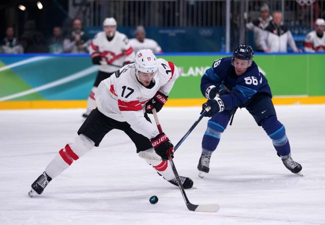 (260219) -- MILAN, Feb. 19, 2026 (Xinhua) -- Ken Jager (L) of Switzerland fights for the puck against Erik Haula of Finland during the ice hockey men's play-offs quarterfinal between Finland and Switzerland at the Milan-Cortina 2026 Olympic Winter Games in Milan, Italy, Feb. 18, 2026. (Xinhua/Tao Xiyi)