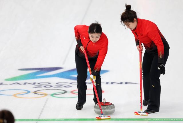 (260219) -- CORTINA D'AMPEZZO, Feb. 19, 2026 (Xinhua) -- Dong Ziqi and Han Yu (L) of China compete during the curling women's round robin session 11 match between China and Sweden at the 2026 Milan-Cortina Winter Olympics in Cortina, Italy, Feb. 18, 2026. (Xinhua/Ding Xu)