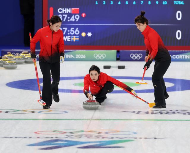 (260219) -- CORTINA D'AMPEZZO, Feb. 19, 2026 (Xinhua) -- Dong Ziqi (R), Han Yu (L) and Jiang Jiayi of China compete during the curling women's round robin session 11 match between China and Sweden at the 2026 Milan-Cortina Winter Olympics in Cortina, Italy, Feb. 18, 2026. (Xinhua/Ding Xu)