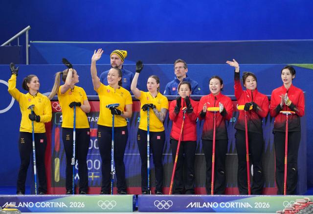(260219) -- CORTINA D'AMPEZZO, Feb. 19, 2026 (Xinhua) -- Players of both teams greet spectators before the curling women's round robin session 11 match between China and Sweden at the 2026 Milan-Cortina Winter Olympics in Cortina, Italy, Feb. 18, 2026. (Xinhua/Li Gang)