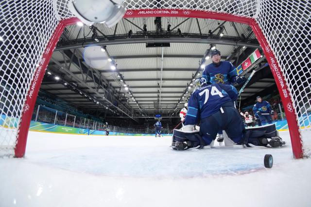 (260219) -- MILAN, Feb. 19, 2026 (Xinhua) -- Juuse Saros (front), goalkeeper of Finland, fails to make a save during the ice hockey men's play-offs quarterfinal between Finland and Switzerland at the Milan-Cortina 2026 Olympic Winter Games in Milan, Italy, Feb. 18, 2026. (Xinhua/Sun Fei)