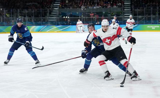 (260219) -- MILAN, Feb. 19, 2026 (Xinhua) -- Ken Jager (1st R) of Switzerland vies for the puck during the ice hockey men's play-offs quarterfinal between Finland and Switzerland at the Milan-Cortina 2026 Olympic Winter Games in Milan, Italy, Feb. 18, 2026. (Xinhua/Sun Fei)