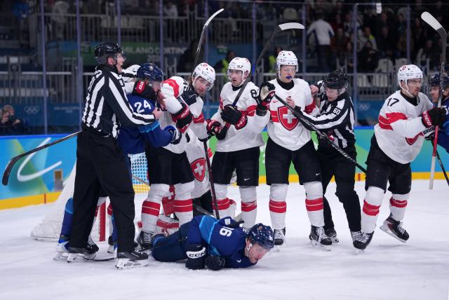 (260219) -- MILAN, Feb. 19, 2026 (Xinhua) -- Players of both teams fight during the ice hockey men's play-offs quarterfinal between Finland and Switzerland at the Milan-Cortina 2026 Olympic Winter Games in Milan, Italy, Feb. 18, 2026. (Xinhua/Tao Xiyi)