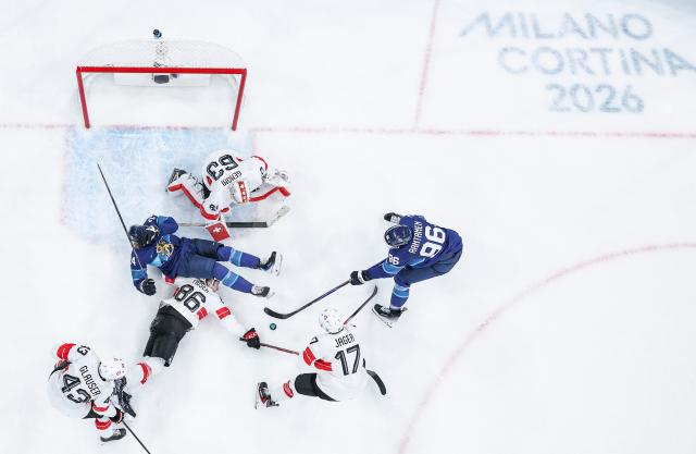 (260219) -- MILAN, Feb. 19, 2026 (Xinhua) -- Players of both teams compete during the ice hockey men's play-offs quarterfinal between Finland and Switzerland at the Milan-Cortina 2026 Olympic Winter Games in Milan, Italy, Feb. 18, 2026. (Xinhua/Sun Fei)