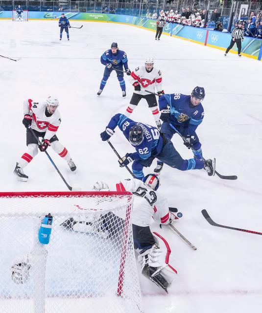 (260219) -- MILAN, Feb. 19, 2026 (Xinhua) -- Leonardo Genoni (bottom), goalkeeper of Switzerland makes a save during the ice hockey men's play-offs quarterfinal between Finland and Switzerland at the Milan-Cortina 2026 Olympic Winter Games in Milan, Italy, Feb. 18, 2026. (Xinhua/Sun Fei)