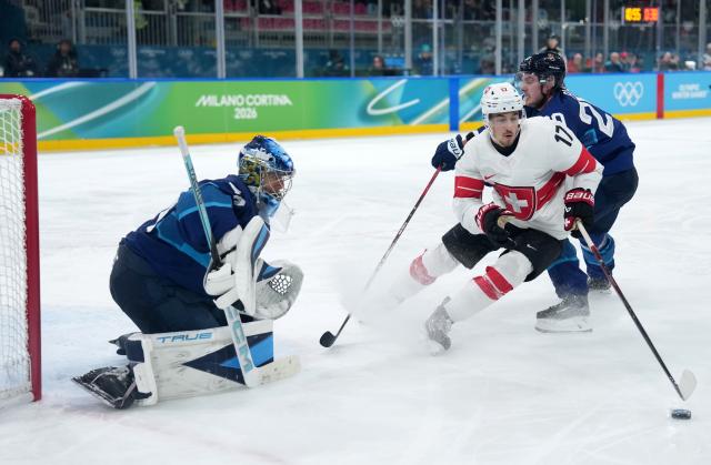 (260219) -- MILAN, Feb. 19, 2026 (Xinhua) -- Ken Jager (C) of Switzerland vies for the puck during the ice hockey men's play-offs quarterfinal between Finland and Switzerland at the Milan-Cortina 2026 Olympic Winter Games in Milan, Italy, Feb. 18, 2026. (Xinhua/Sun Fei)