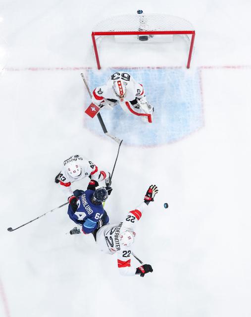 (260219) -- MILAN, Feb. 19, 2026 (Xinhua) -- Players of both teams compete during the ice hockey men's play-offs quarterfinal between Finland and Switzerland at the Milan-Cortina 2026 Olympic Winter Games in Milan, Italy, Feb. 18, 2026. (Xinhua/Sun Fei)