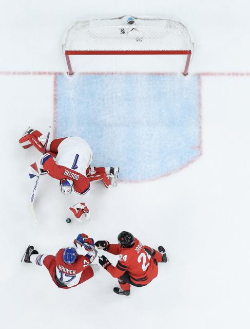 (260219) -- MILAN, Feb. 19, 2026 (Xinhua) -- Lukas Dostal (top), goalkeeper of the Czech Republic, makes a save during the ice hockey men's play-offs quarterfinals match between Canada and the Czech Republic at the Milan-Cortina 2026 Olympic Winter Games in Milan, Italy, Feb. 18, 2026. (Xinhua/Zhang Haofu)