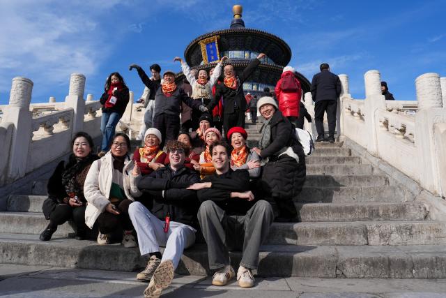 (260219) -- BEIJING, Feb. 19, 2026 (Xinhua) -- Dutch tourists David (L, front) and Pim (R, front) pose for photos with Chinese tourists at the Tiantan (Temple of Heaven) Park in Beijing, capital of China, Jan. 7, 2026. (Xinhua/Ju Huanzong)
