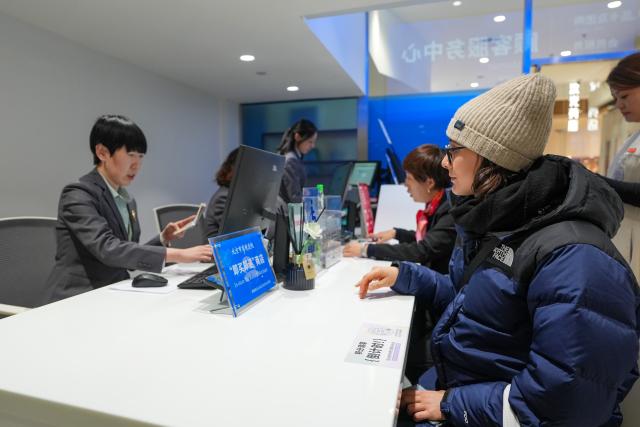 (260219) -- BEIJING, Feb. 19, 2026 (Xinhua) -- Italian tourist Chiara Manuzzi (R, front) enquires tax refund policies at a shopping mall in Beijing, capital of China, Jan. 6, 2026. (Xinhua/Ju Huanzong)