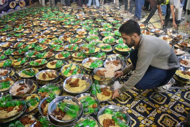 (260219) -- KARACHI, Feb. 19, 2026 (Xinhua) -- A volunteer prepares food plates which will be distributed among people for pre-dawn meals to start their fasting during the Muslim's holy fasting month of Ramadan, in Karachi, Pakistan, on Feb. 19, 2026. (Str/Xinhua)