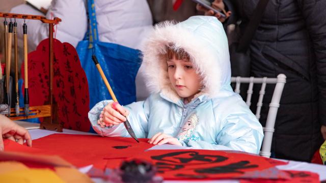 (260219) -- BEIJING, Feb. 19, 2026 (Xinhua) -- A kid tries Chinese calligraphy during an event celebrating the Spring Festival in Belgrade, Serbia, Feb. 17, 2026. A series of events celebrating the Spring Festival were held here on Monday and Tuesday, creating a festive atmosphere and attracting thousands of local residents and members from the Chinese community. (Photo by Wang Wei/Xinhua)