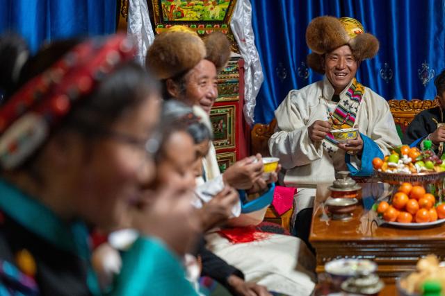 (260219) -- LHASA, Feb. 19, 2026 (Xinhua) -- Sangs-rgyas (1st, R) enjoys "gutu," a kind of soup made of flour, with his family at home in Gurum Village of Chamco Township, Dingri County, southwest China's Xizang Autonomous Region, Feb. 16, 2026.  "Gu" in Tibetan means nine and "Tu" means pasta. At the Night of Gutu, the whole family and relatives gather to enjoy the dish and celebrate the occasion.
  Monday was the Chinese New Year's Eve, which coincided with the Night of Gutu of the Tibetan calendar. Enjoying the festive atmosphere, the family of Sangs-rgyas purchased new furniture and stocked up on New Year goods, celebrating their first Spring Festival and Tibetan New Year after moving into their new house.
  Last year, a 6.8 magnitude earthquake hit Dingri, home to the northern base camp of the world's highest peak, Mount Qomolangma, and other counties in the region on Jan. 7. In less than three days after the earthquake, Xizang rolled out a post-disaster reconstruction plan and kicked off the reconstruction work later. In the second half of 2025, the family of Sangs-rgyas moved into a safe and comfortable new residence. (Xinhua/Tenzing Nima Qadhup)