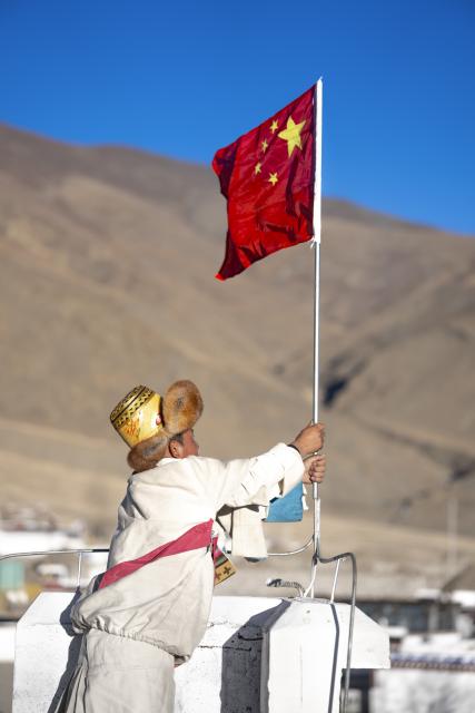 (260219) -- LHASA, Feb. 19, 2026 (Xinhua) -- Sangs-rgyas places a Chinese national flag on top of his roof in Gurum Village of Chamco Township, Dingri County, southwest China's Xizang Autonomous Region, Feb. 16, 2026.
  Monday was the Chinese New Year's Eve, which coincided with the Night of Gutu of the Tibetan calendar. Enjoying the festive atmosphere, the family of Sangs-rgyas purchased new furniture and stocked up on New Year goods, celebrating their first Spring Festival and Tibetan New Year after moving into their new house.
  Last year, a 6.8 magnitude earthquake hit Dingri, home to the northern base camp of the world's highest peak, Mount Qomolangma, and other counties in the region on Jan. 7. In less than three days after the earthquake, Xizang rolled out a post-disaster reconstruction plan and kicked off the reconstruction work later. In the second half of 2025, the family of Sangs-rgyas moved into a safe and comfortable new residence. (Xinhua/Tenzing Nima Qadhup)