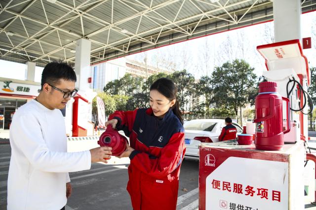 (260219) -- BEIJING, Feb. 19, 2026 (Xinhua) -- A staff member serves hot water for a driver at a gas station in Jiyuan City, central China's Henan Province, Feb. 19, 2026. During the Spring Festival travel season, civil aviation, railway, and other departments have increased transportation capacity and optimized convenient services such as air-rail intermodal transport, quiet carriages, luggage delivery, and priority channels for vulnerable groups, taking multiple measures to ensure passengers' safe and smooth travel. (Photo by Miao Qiunao/Xinhua)