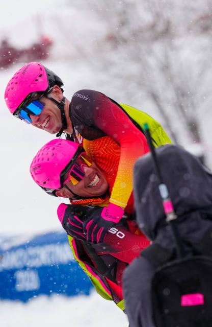 (260219) -- BORMIO, Feb. 19, 2026 (Xinhua) -- Oriol Cardona Coll (top) of Spain celebrates with his teammate after the ski mountaineering men's sprint event at the Milan-Cortina 2026 Olympic Winter Games in Bormio, Italy, Feb. 19, 2026. (Xinhua/Yan Linyun)