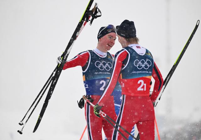 (260219) -- TESERO, Feb. 19, 2026 (Xinhua) -- Jens Luraas Oftebro (L) and Andreas Skoglund of Norway celebrate after the cross-country event of the nordic combined team sprint at the 2026 Milan-Cortina Winter Olympics in Tesero, Italy, Feb. 19, 2026. (Xinhua/He Canling)