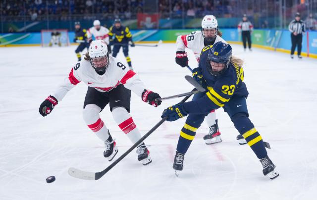 (260219) -- MILAN, Feb. 19, 2026 (Xinhua) -- Thea Johansson (R) of Sweden passes the puck during the ice hockey women's bronze medal game between Switzerland and Sweden at the Milan-Cortina 2026 Olympic Winter Games in Milan, Italy, Feb. 19, 2026. (Xinhua/Tao Xiyi)