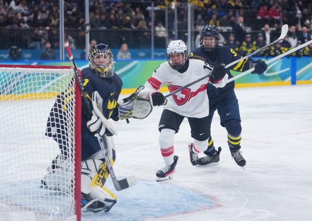 (260219) -- MILAN, Feb. 19, 2026 (Xinhua) -- Lisa Ruedi of Switzerland (C), Jessica Adolfsson of Sweden (R) and goalkeeper Ebba Svensson Traff of Sweden gaze at the puck during the ice hockey women's bronze medal game between Switzerland and Sweden at the Milan-Cortina 2026 Olympic Winter Games in Milan, Italy, Feb. 19, 2026. (Xinhua/Tao Xiyi)