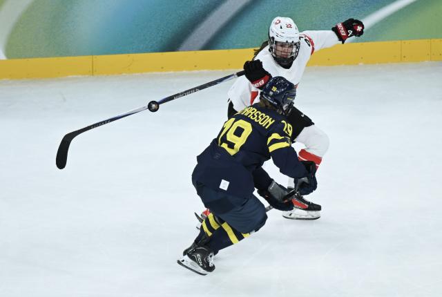 (260219) -- MILAN, Feb. 19, 2026 (Xinhua) -- Sara Hjalmarsson (front) of Sweden vies with Sinja Leemann of Switzerland during the ice hockey women's bronze medal game between Switzerland and Sweden at the Milan-Cortina 2026 Olympic Winter Games in Milan, Italy, Feb. 19, 2026. (Xinhua/Zhang Haofu)