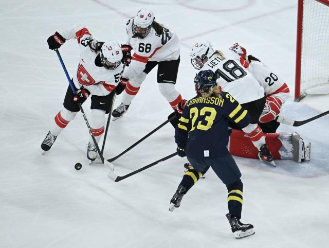 (260219) -- MILAN, Feb. 19, 2026 (Xinhua) -- Players vie for the puck during the ice hockey women's bronze medal game between Switzerland and Sweden at the Milan-Cortina 2026 Olympic Winter Games in Milan, Italy, Feb. 19, 2026. (Xinhua/Zhang Haofu)