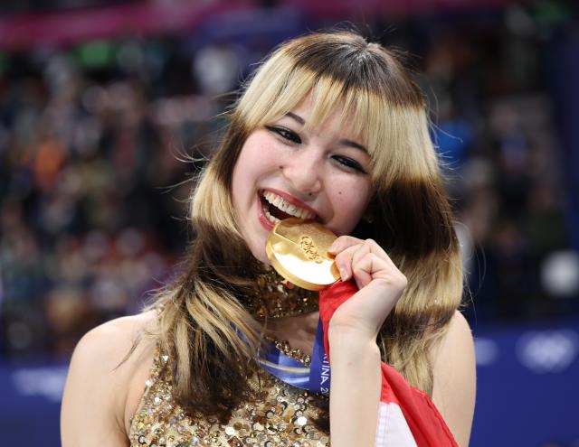 (260219) -- MILAN, Feb. 19, 2026 (Xinhua) -- Gold medalist Alysa Liu of the United States bites her medal during the awarding ceremony of the figure skating women single skating event at the Milan-Cortina 2026 Olympic Winter Games in Milan, Italy, Feb. 19, 2026. (Xinhua/Li Ming)