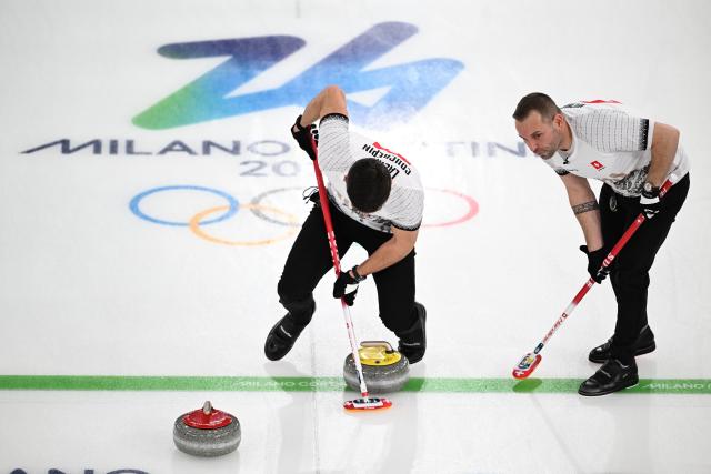 (260220) -- CORTINA D'AMPEZZO, Feb. 20, 2026 (Xinhua) -- Pablo Lachat-Couchepin (L) of Switzerland competes during the curling men's semi-final match between Britain and Switzerland at the 2026 Milan-Cortina Winter Olympics in Cortina, Italy, Feb. 19, 2026. (Xinhua/Lian Yi)