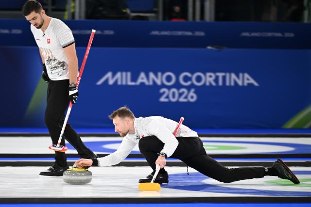 (260220) -- CORTINA D'AMPEZZO, Feb. 20, 2026 (Xinhua) -- Yannick Schwaller (R) of Switzerland competes during the curling men's semi-final match between Britain and Switzerland at the 2026 Milan-Cortina Winter Olympics in Cortina, Italy, Feb. 19, 2026. (Xinhua/Lian Yi)
