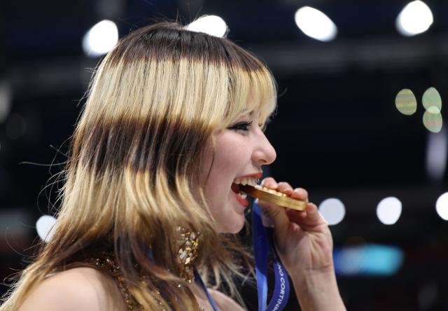 (260220) -- MILAN, Feb. 20, 2026 (Xinhua) -- Gold medalist Alysa Liu of the United States bites her medal after the awarding ceremony of the figure skating women single skating event at the Milan-Cortina 2026 Olympic Winter Games in Milan, Italy, Feb. 19, 2026. (Xinhua/Li Ming)