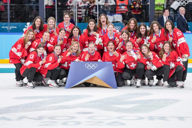 (260220) -- MILAN, Feb. 20, 2026 (Xinhua) -- Bronze medalists players of Switzerland pose for photos during the awarding ceremony for the ice hockey women's gold medal game between the United States and Canada at the Milan-Cortina 2026 Olympic Winter Games in Milan, Italy, Feb. 19, 2026. (Xinhua/Sun Fei)