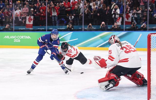 (260220) -- MILAN, Feb. 20, 2026 (Xinhua) -- Megan Keller (L) of the United States scores the winning goal against Canada during the ice hockey women's gold medal game between the United States and Canada at the Milan-Cortina 2026 Olympic Winter Games in Milan, Italy, Feb. 19, 2026. (Xinhua/Wang Kaiyan)