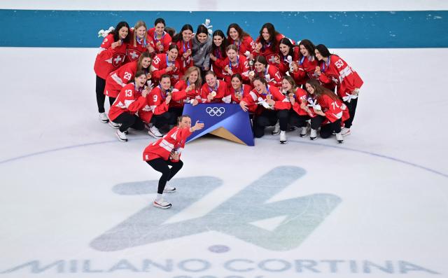 (260220) -- MILAN, Feb. 20, 2026 (Xinhua) -- Bronze medalists players of Switzerland pose for selfies during the awarding ceremony after the ice hockey women's gold medal game between the United States and Canada at the Milan-Cortina 2026 Olympic Winter Games in Milan, Italy, Feb. 19, 2026. (Xinhua/Tao Xiyi)