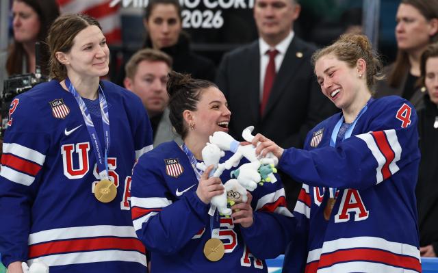 (260220) -- MILAN, Feb. 20, 2026 (Xinhua) -- Caroline Harvey (R) of the United States interacts with teammate Cayla Barnes during the awarding ceremony after the ice hockey women's gold medal game between the United States and Canada at the Milan-Cortina 2026 Olympic Winter Games in Milan, Italy, Feb. 19, 2026. (Xinhua/Wang Kaiyan)
