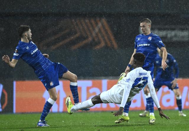 (260220) -- ZAGREB, Feb. 20, 2026 (Xinhua) -- Fran Topic (L) and Luka Stojkovic (R) of GNK Dinamo vie with Aaron Bibout of KRC Genk during the UEFA Europa League 2025/26 Knockout Play-off First Leg match between GNK Dinamo and KRC Genk at Stadion Maksimir in Zagreb, Croatia, on Feb. 19, 2026. (Photo by Marko Lukunic/PIXSELL via Xinhua)