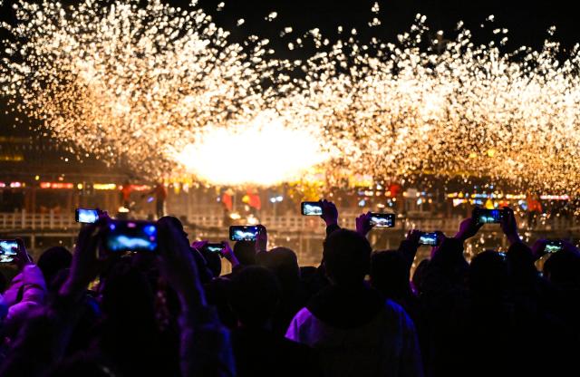 (260220) -- BEIJING, Feb. 20, 2026 (Xinhua) -- Tourists watch molten iron fireworks at a temple fair in Shangqiu City, central China's Henan Province, Feb. 19, 2026. China's Ministry of Culture and Tourism launched a month-long cultural and tourism campaign ahead of the Spring Festival, featuring a wide range of activities and promotional measures to better meet people's needs.
   Running from late January to early March, the campaign will see about 30,000 activities held nationwide, offering seasonal cultural and tourism products and events focused on traditional New Year customs, performances, and exhibitions.
   More than 360 million yuan (about 51.6 million U.S. dollars) in consumption vouchers and subsidies will be distributed, alongside measures such as ticket discounts, bundled ticket incentives, and cross-regional tourism promotions. (Photo by Li Heng/Xinhua)