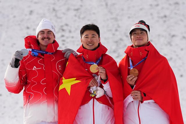 (260220) -- LIVIGNO, Feb. 20, 2026 (Xinhua) -- Silver medalist Noe Roth of Switzerland, gold medalist Wang Xindi of China and his teammate bronze medalist Li Tianma (L to R) pose during the awarding ceremony of the freestyle skiing men's aerials at the Milan-Cortina 2026 Olympic Winter Games in Livigno, Italy, Feb. 20, 2026. (Xinhua/Wu Huiwo)
