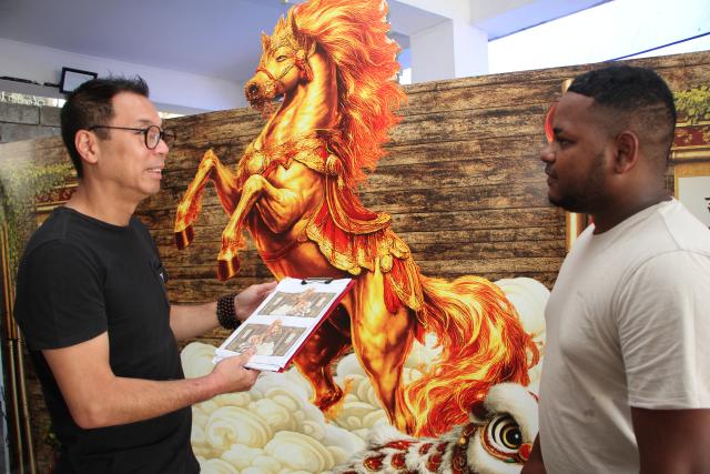 (260220) -- PORT LOUIS, Feb. 20, 2026 (Xinhua) -- Jacques Li (L), head of a float workshop, discusses details of float production with an artisan at his float workshop in Port Louis, the capital of Mauritius, Feb. 11, 2026. TO GO WITH "Feature: Spring Festival spirit builds in Mauritius as float parade approaches" (Photo by Ally Soobye/Xinhua)