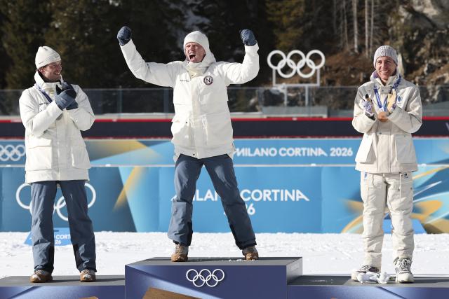 (260220) -- ANTERSELVA, Feb. 20, 2026 (Xinhua) -- Gold medalist Johannes Dale-Skjevdal (C) of Norway celebrates during the awarding ceremony of the biathlon men's 15km mass start event at the 2026 Milan-Cortina Winter Olympics in Anterselva, Italy, Feb. 20, 2026. (Xinhua/Zhang Tao)