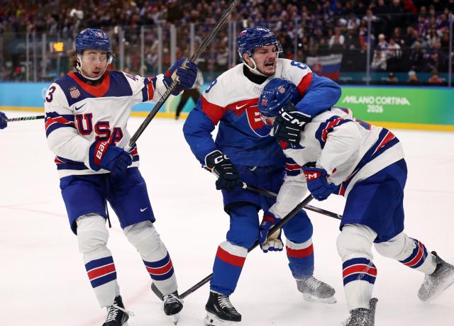 (260221) -- MILAN, Feb. 21, 2026 (Xinhua) -- Oliver Okuliar (C) of Slovakia fights with Charlie McAvoy (R) and Quinn Hughes of the United States during the ice hockey men's play-offs semifinal match between the United States and Slovakia at the Milan-Cortina 2026 Olympic Winter Games in Milan, Italy, Feb. 20, 2026. (Xinhua/Wang Kaiyan)