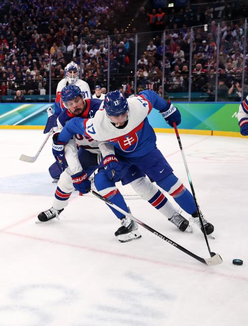 (260221) -- MILAN, Feb. 21, 2026 (Xinhua) -- Simon Nemec (front R) of Slovakia and Auston Matthews (front L) of the United States battle for the puck during the ice hockey men's play-offs semifinal match between the United States and Slovakia at the Milan-Cortina 2026 Olympic Winter Games in Milan, Italy, Feb. 20, 2026. (Xinhua/Wang Kaiyan)