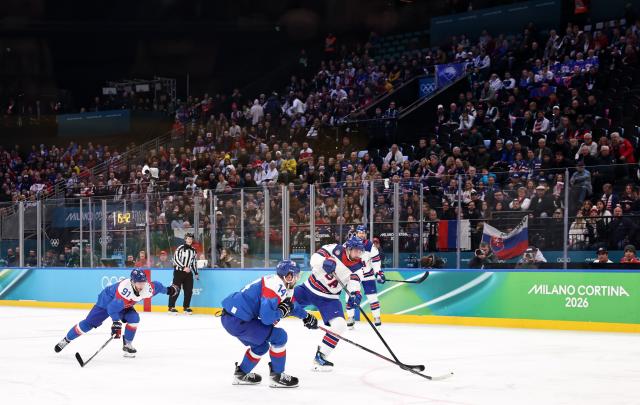 (260221) -- MILAN, Feb. 21, 2026 (Xinhua) -- Dylan Larkin (front R) of the United States shoots to score during the ice hockey men's play-offs semifinal match between the United States and Slovakia at the Milan-Cortina 2026 Olympic Winter Games in Milan, Italy, Feb. 20, 2026. (Xinhua/Wang Kaiyan)