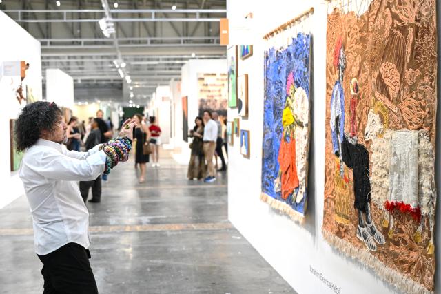 (260221) -- CAPE TOWN, Feb. 21, 2026 (Xinhua) -- A visitor takes a photo of an artwork during the Cape Town Art Fair 2026 at the Cape Town International Convention Center in Cape Town, South Africa, Feb. 20, 2026.
  The Cape Town Art Fair 2026 kicked off here on Friday. This year's edition takes place from Feb. 20 to 22 at the Cape Town International Convention Center, featuring 126 exhibitors from 34 global cities and showcasing works by more than 490 artists, with over 30,000 visitors expected. (Photo by Xabiso Mkhabela/Xinhua)