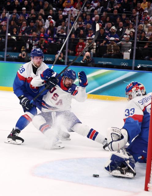 (260221) -- MILAN, Feb. 21, 2026 (Xinhua) -- Auston Matthews (C) of the United States competes with Martin Gernat (L) of Slovakia during the ice hockey men's play-offs semifinal match between the United States and Slovakia at the Milan-Cortina 2026 Olympic Winter Games in Milan, Italy, Feb. 20, 2026. (Xinhua/Wang Kaiyan)