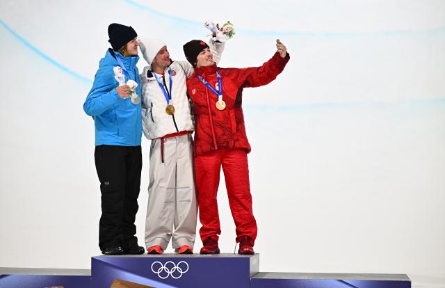 (260221) -- LIVIGNO, Feb. 21, 2026 (Xinhua) -- Gold medallist Alex Ferreira (C) of the United States, silver medalist Henry Sildaru (L) of Estonia and bronze medallist Brendan Mackay of Canada pose for selfies during the awarding ceremony after the freestyle skiing men's freeski halfpipe final at the Milan-Cortina 2026 Olympic Winter Games in Livigno, Italy, Feb. 20, 2026. (Xinhua/Zhang Hongxiang)