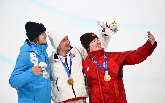 (260221) -- LIVIGNO, Feb. 21, 2026 (Xinhua) -- Gold medallist Alex Ferreira (C) of the United States, silver medalist Henry Sildaru (L) of Estonia and bronze medallist Brendan Mackay of Canada pose for selfies during the awarding ceremony after the freestyle skiing men's freeski halfpipe final at the Milan-Cortina 2026 Olympic Winter Games in Livigno, Italy, Feb. 20, 2026. (Xinhua/Zhang Hongxiang)